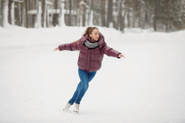 Girl skater at an outdoor rink in winter © olgasparrow