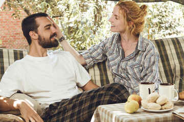 young attractive couple in love having breakfast outdoors