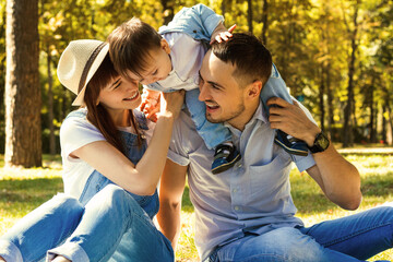 Family vacation. Father, mother and son having picnic in summer park