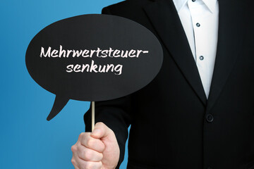 Mehrwertsteuersenkung. Mann im Anzug hält Sprechblase in der Hand. Der Text Mehrwertsteuersenkung...