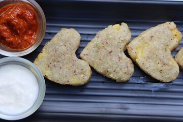 Sabudana vada or wada, sabu vada, traditional deep fried snack made with tapioca balls from Maharashtra, India, served with curd 