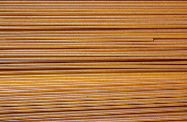 The background is dark-colored Italian spaghetti. Italian Macaroni Pasta raw food background or texture close up.