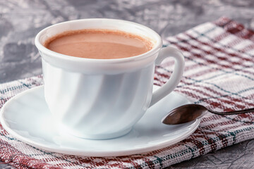 Freshly brewed aromatic coffee with cream on a gray background