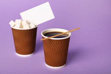 Takeaway cups of coffee with sugar business card on color background