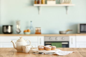 Fototapeta na wymiar Tasty muffins with tea on kitchen table