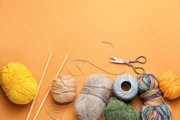 Scissors with knitting yarn and needles on color background