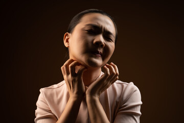 Fototapeta na wymiar Asian woman was sick with irritate itching her skin standing isolated on beige background.
