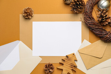 Christmas composition with blank card and envelopes on color background