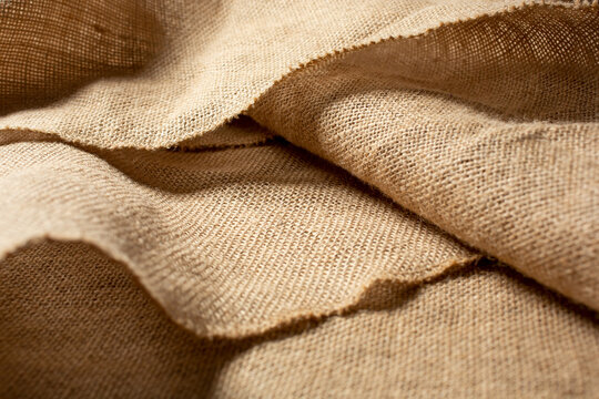 A view of creases, folds, and layers in burlap material, as a background image.