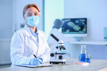 Scientist working with microscope in laboratory