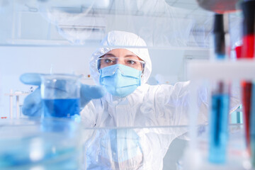 Fototapeta premium Scientist taking glassware from shelf in laboratory