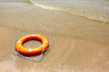 Bright lifebuoy ring on beach