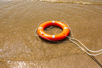 Bright lifebuoy ring on beach