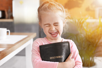 Little girl with Bible at home