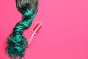 Unusual wig and brush on color background