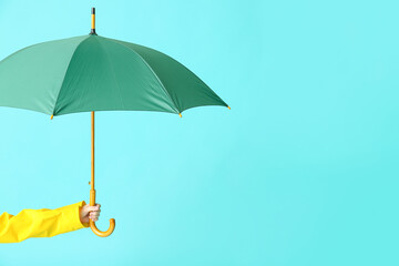 Hand with stylish umbrella on color background