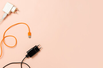 Various plugs and cables on pastel background, copyspace. Flatlay, technology or connection concept