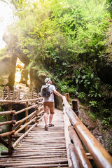 Naklejka na ściany i meble backpacker walking by wooden trail caglieron caves in italy.