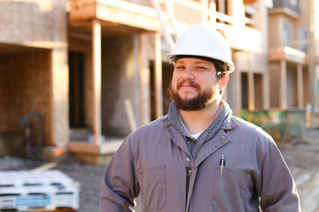 Portrait of american engineer wearing hardhat on constuction site.