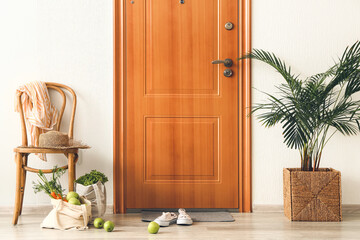 Eco bags with fresh products from market and shoes in hall