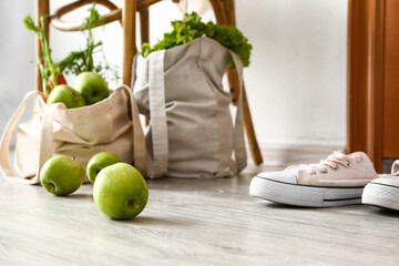 Eco bags with fresh products from market and shoes in hall