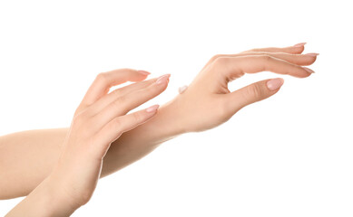 Beautiful young woman applying hand cream against white background