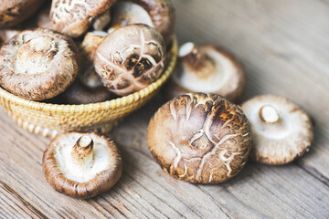 Obraz na płótnie Canvas Fresh mushrooms on basket and wooden table background - Shiitake mushrooms