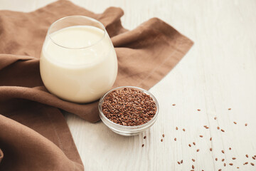 Glass of yogurt and flax seeds on white table