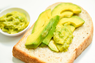 Avocado sliced and avocado toast on white plate background fruits healthy food concept - avocado dip mashed