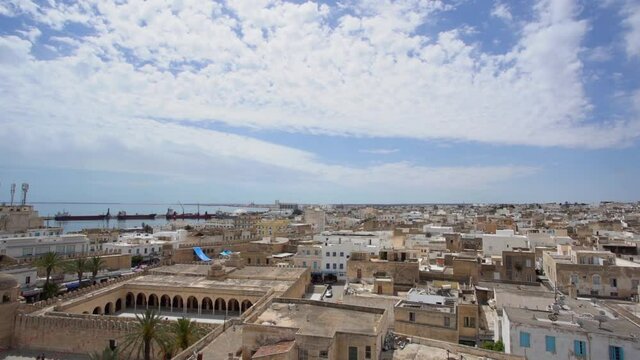 Aerial view of Tunisian cityscape of  streets of Sousse city in Tunisia country. Different old and modern architecture, cargo ship in sea, ancient walls of old historical buildings.