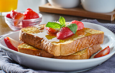 french toast with strawberries and syrup