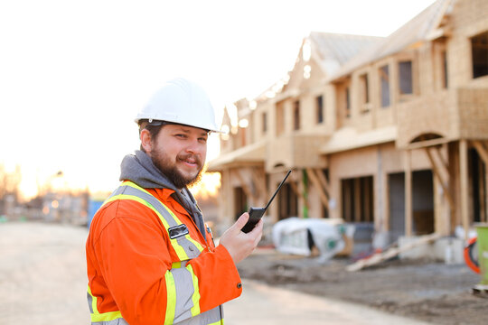 Portrait of european engineer talking by walkie talkie on construction site.