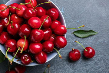 Bowl with sweet cherry on table