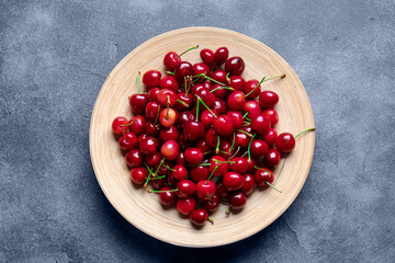 Plate with sweet cherry on table