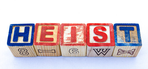 The term heist displayed visually on a clear background using toy blocks image in horizontal format...