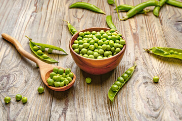 Bowl and spoon with tasty fresh peas on table