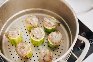 Stuffed zuccini pieces decorated with shrimps cooking in steamer for dinner