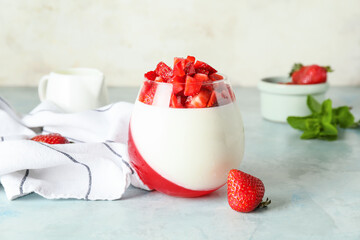 Tasty strawberry dessert in glass on table