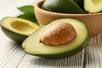 Bowl with fresh avocado on wooden background, close up