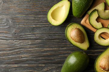 Board and avocado on wooden background, top view
