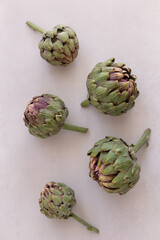 Obraz premium Topview image of artichokes on a light gray background.