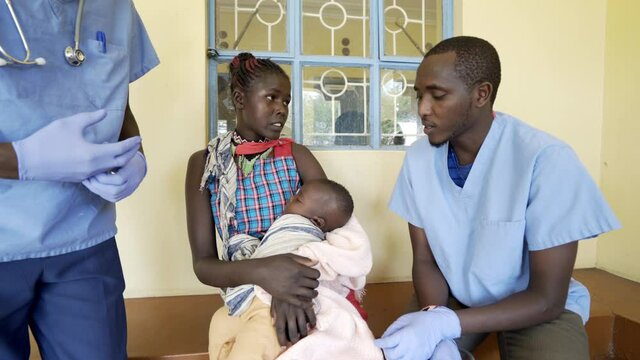 Doctors working with mothers and babies in busy neonatal clinic. Africa