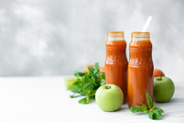 freshly squeezed carrot juice in bottles with vegetables