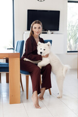 Young smiling woman with dog at home indoor