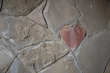Stone wall cladding. Among the usual forms, there is a heart-shaped stone. Declaration of love. A symbol, a sign of love.