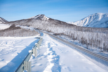 Scenic winter landscape of Kolyma Highway (Road of Bones) with amazing Verkhoyansk mountain Range on the background. Adventure travel in Russia from Yakutsk to Magadan