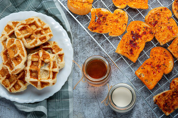 Traditional Belgian waffles, blood oranges and blueberries dressing and cup of coffee for sweet breakfast, composition on light background.
