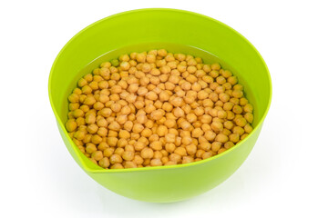 Soaked yellow chickpeas before cooking in the plastic kitchen bowl