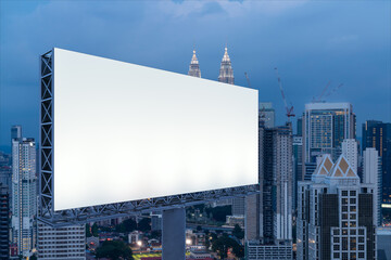 Blank white road billboard with KL cityscape background at night time. Street advertising poster, mock up, 3D rendering. Side view. The concept of marketing communication to promote or sell idea.