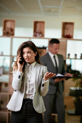 Businesswoman talking to the phone. Happy young woman working in office.	